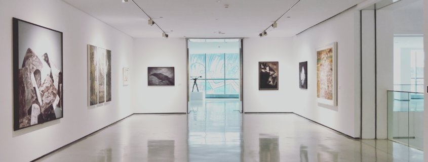 An art gallery with white walls and paintings on the walls